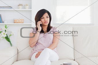 Woman sitting on a couch holding a phone