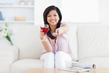 Woman sitting in a white couch while holding a glass of red wine