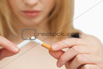 Serious woman breaking a cigarette