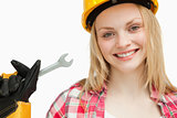 Smiling woman holding a wrench