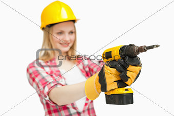 Cheerful woman using an electric screwdriver