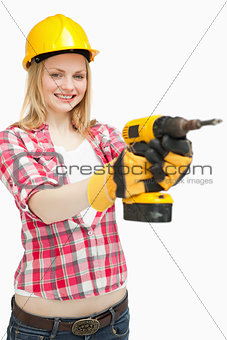 Woman using an electric screwdriver while smiling
