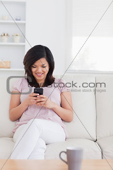 Woman sitting on a couch and holding a phone