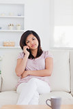 Woman phoning while sitting on a couch