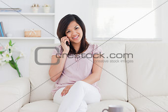 Woman with a smile on her face sitting on a couch