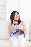 Woman smiling while sitting on a sofa and holding a glass of win