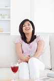 Woman laughing while sitting on a sofa