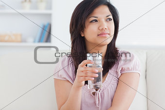 Woman sitting on a sofa and holding a glass