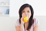 Woman smiling while drinking a glass of orange juice
