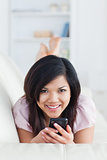 Woman relaxing on a sofa while holding a phone