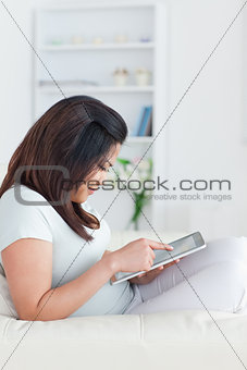 Woman sitting on a sofa while holding a tablet
