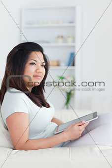 Woman sitting on a couch and holding a tablet