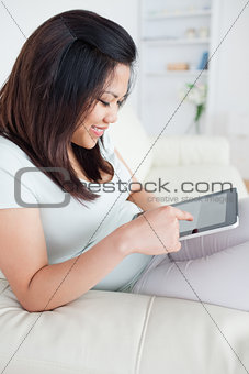 Woman holding a tablet while sitting on a couch