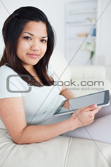 Woman sitting on a couch while holding a tactile tablet