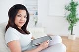 Woman sitting on a sofa while holding a tactile tablet