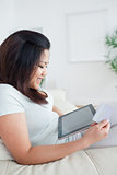 Woman looking at a tactile tablet while sitting on a couch