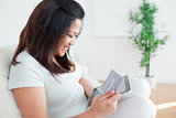 Woman on a couch while holding a tactile tablet and a card