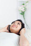 Woman lying on a sofa with headphones on