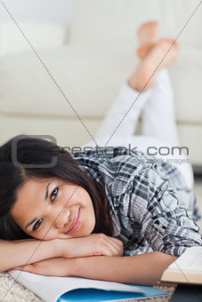 Woman crossing her legs and her arms as she lays on the floor