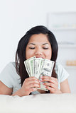 Woman closing her eyes as she holds some dollar bills