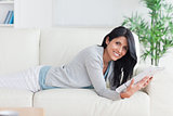 Woman holding a magazine while relaxing on a couch