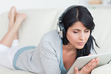 Woman wearing headphones and holding a tablet