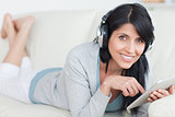 Smiling woman with headphones on while holding a tablet