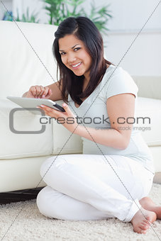 Smiling woman holding a tactile tablet in front of a couch