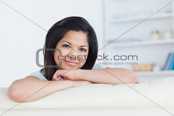 Smiling woman crossing her arms on a white sofa