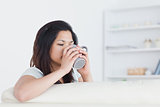 Woman drinking from a mug while holding it with two hands