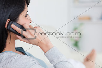 Woman lying on a couch and phoning