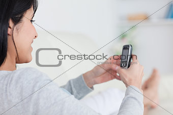 Woman smiling while typing on a phone
