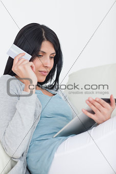 Woman holding a credit card and a tablet