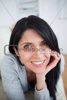 Smiling woman holding her  head with her hand