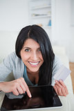 Woman smiling while touching a tactile tablet screen and holding