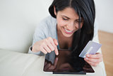 Woman touching a tactile tablet and holding a credit card
