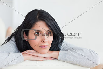 Woman crossing her arms under her head on a sofa
