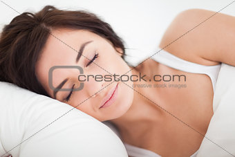 Peaceful brown-haired woman sleeping in the bed
