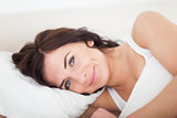 Smiling brunette woman waking up