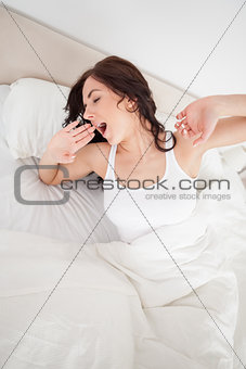 Brunette woman yawning while waking up
