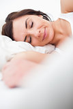 Brunette woman closing her eyes while lying