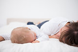 Brunette woman and her baby lying together