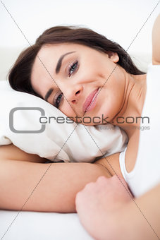 Peaceful woman waking up while lying in her bed
