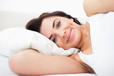 Smiling woman lying while waking up
