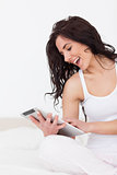 Cheerful woman holding her tablet pc while sitting