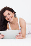 Happy brunette woman using her tablet computer