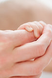 Hand holding the little hand of a baby