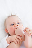 Cute baby placing her foot on her mouth