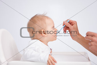 Baby eating her meal with a spoon