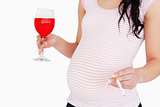 Young pregnant  woman holding a cocktail and a cigarette